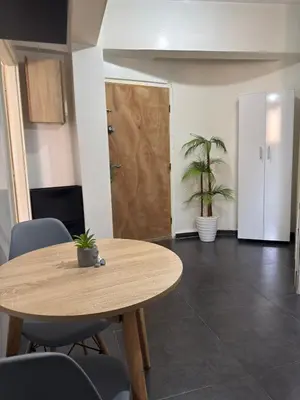 a wooden table and chairs in a room with a door at Appartement au centre ville pour les mariés seulement in Rabat