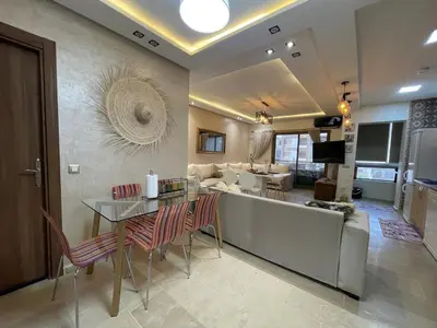 a living room with a couch and a table at Appartement Balneaire avec piscine à El Mansouria in Mansouria