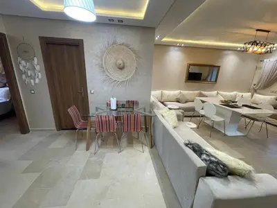a living room with a couch and a table at Appartement Balneaire avec piscine à El Mansouria in Mansouria
