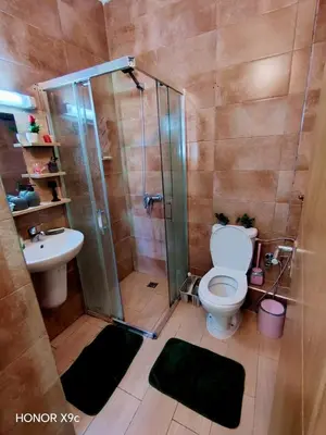 a bathroom with a shower and a toilet and a sink at appartement avec piscines in Mansouria