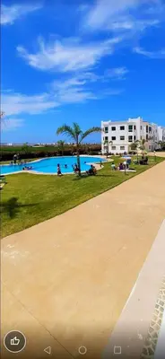 a large swimming pool with people in a park at appartement avec piscines in Mansouria