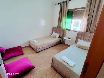 a small room with two beds and a couch at appartement avec piscines in Mansouria