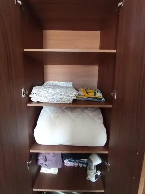 a cabinet with a bed and pillows in it at Charming appartement in Bouznika in Bouznika
