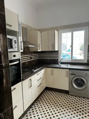 a kitchen with white cabinets and a washer and dryer at Casa Amy in Mohammedia