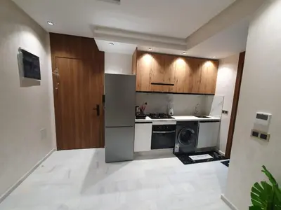 a kitchen with a refrigerator and a stove top oven at Studio Parc Mohammedia in Mohammedia
