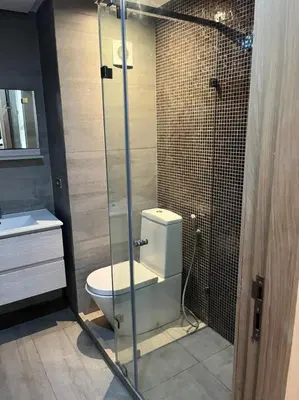 a bathroom with a toilet and a glass shower at beach front gardens in Mohammedia