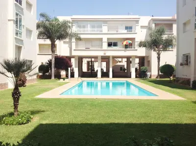 a swimming pool in front of a building at Appartement en bord de mer à Harhoura in Temara