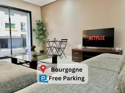 a living room with a tv and a bed and a table at Rihla Stays - Anfa City in Casablanca
