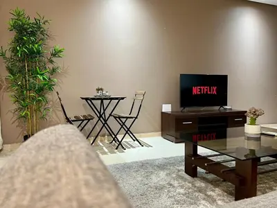 a living room with a tv and a table at Rihla Stays - Anfa City in Casablanca