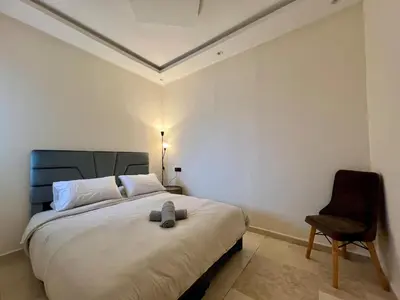 a bedroom with a large bed and a chair at Casablanca Central Suites - Casa Voyageurs in Casablanca