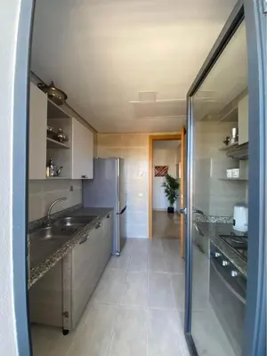 a kitchen with a sink and a refrigerator at Résidence yassmin in Rabat