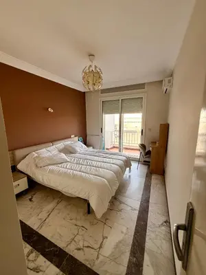 a bedroom with a large bed and a chandelier at Luxury Apartment Ocean View and Private Beach Ain Diab in Casablanca