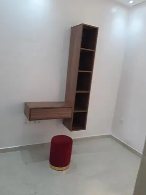 a book shelf and a red stool in a room at Appartement 3 chambres et Salon sans ascenseur 3 mn à pied au Parc du Mohammedia in Mohammedia