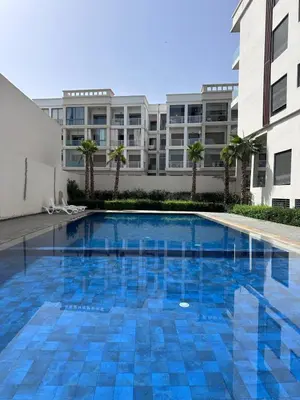 a swimming pool in front of a building at Appartement moderne avec piscine, 2 chambres in Bouznika