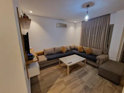 a living room with a couch and a table at Blue beach in Bir Jedíd Saint-Hubert