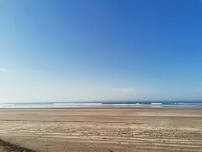 an empty beach with the ocean in the background at Blue beach in Bir Jedíd Saint-Hubert