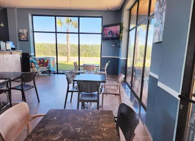 a dining room with tables and chairs and windows at Blue beach in Bir Jedíd Saint-Hubert