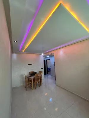 a dining room with a table and some lights at apartment in sidi rahal in Sidi Rahal