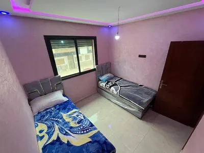two beds in a room with a window at apartment in sidi rahal in Sidi Rahal