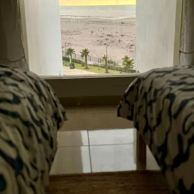 a bedroom with a view of the beach from a window at Dokkali