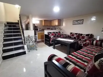 a living room with couches and a table and a kitchen at Studio with Swimmingpool in Harhoura in Temara