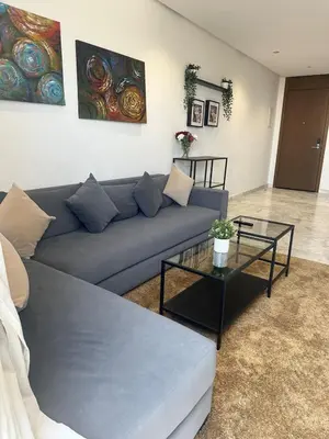 a living room with a blue couch and a table at Charming Studio in Oasis in Oulad Akkou