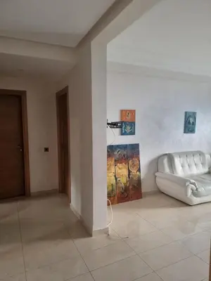 a room with a white couch and a painting on the wall at Appartement Confortable à Tamaris Piscine, Jacuzzi, Proche de la Mer in Tamaris