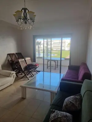 a living room with a couch and a glass table at Appartement Confortable à Tamaris Piscine, Jacuzzi, Proche de la Mer in Tamaris