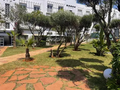 a park with trees and a building in the background at Luxury Sea View in Tamaris