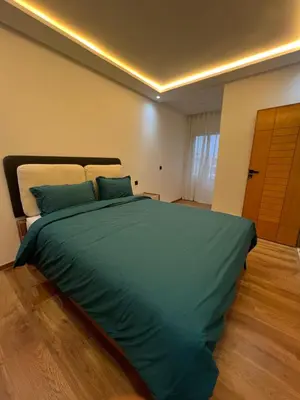 a bedroom with a large bed with green sheets at Magnifique appartement 2 chambres vue sur piscine - Sidi Rahal in Sidi Rahal