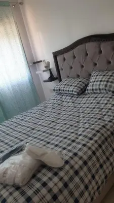 a bed with a checkered blanket and pillows at Mansouria in Mohammedia