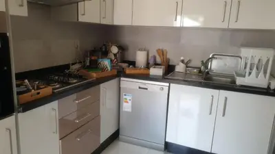 a kitchen with white cabinets and a counter top at Mansouria in Mohammedia