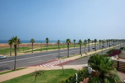 a road with palm trees on the side of the road at Coastal Moroccan Retreat with Ocean Views in Rabat