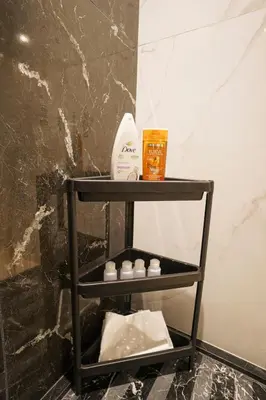 a black shelf in a bathroom with a bottle of soap at Central and Chic Apartment in the Heart of Casablanca Near To Station Tramway Abdelmoumen in Casablanca