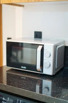 a microwave sitting on top of a counter at Central and Chic Apartment in the Heart of Casablanca Near To Station Tramway Abdelmoumen in Casablanca