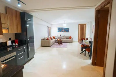 a kitchen and living room with a couch and a table at Central and Chic Apartment in the Heart of Casablanca Near To Station Tramway Abdelmoumen in Casablanca