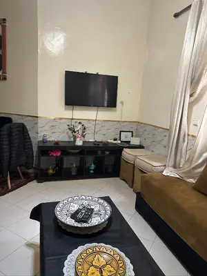 a living room with a couch and a flat screen tv at Studio Résidence Nakhil in Mohammedia