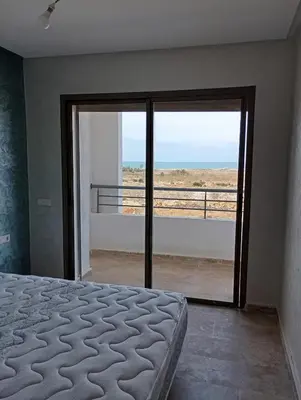 a bedroom with a bed and a view of the ocean at Location de vacances 3 chambres in Mansouria