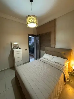 a bedroom with a large bed and a light at Dar al Bahr à Blanca beach Sidi Rehal in Sidi Rahal