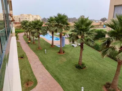 a view of a resort with palm trees and a swimming pool at Evasion Prince 1 in Sidi el Haj Bou Derbala