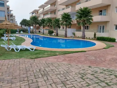 a swimming pool in front of a building at Evasion Prince 1 in Sidi el Haj Bou Derbala