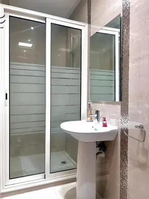 a bathroom with a sink and a glass shower at Villa près de la mer, sidi rahal route de dar bouazza in Bir Jedíd Saint-Hubert