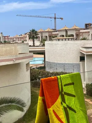 a towel hanging on a clothes line in front of a house at Villa près de la mer, sidi rahal route de dar bouazza in Bir Jedíd Saint-Hubert