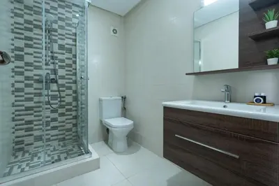 a bathroom with a shower and a toilet and a sink at Détente en Famille, Piscine, Plage à Proximité in Bouznika