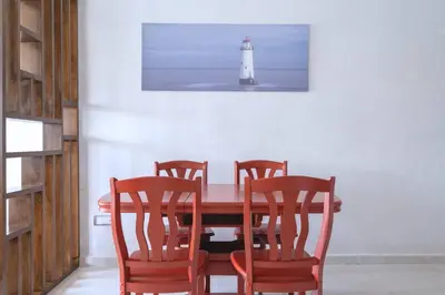 a dining room with a table with four chairs and a lighthouse at Détente en Famille, Piscine, Plage à Proximité in Bouznika