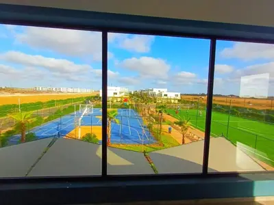 a view of a tennis court from a window at Les Sables de Sidi Rahal - Blue Beach in Sidi Rahal
