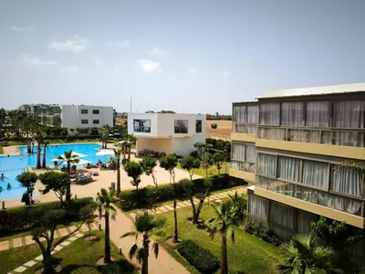 an aerial view of a resort with a pool and palm trees at Les Sables de Sidi Rahal - Blue Beach in Sidi Rahal