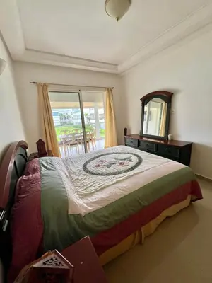 a bedroom with a large bed and a mirror at OlaBlanca2, appartement avec terrasse et vue sur piscine in Sidi Rahal