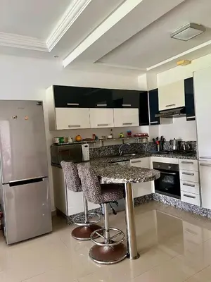 a kitchen with a granite counter top and stainless steel appliances at OlaBlanca2, appartement avec terrasse et vue sur piscine in Sidi Rahal