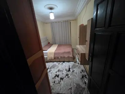 a small room with a bedroom with a bed and a door at Appartement Souka Fitness in Bouznika